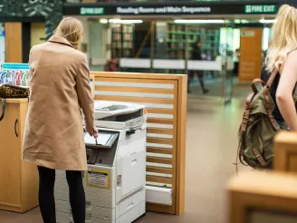 Woman using colour printer in school