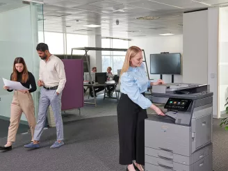 A woman using an MFP in an office