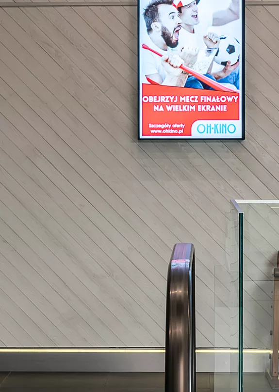 Digital signage screens at top of escalator